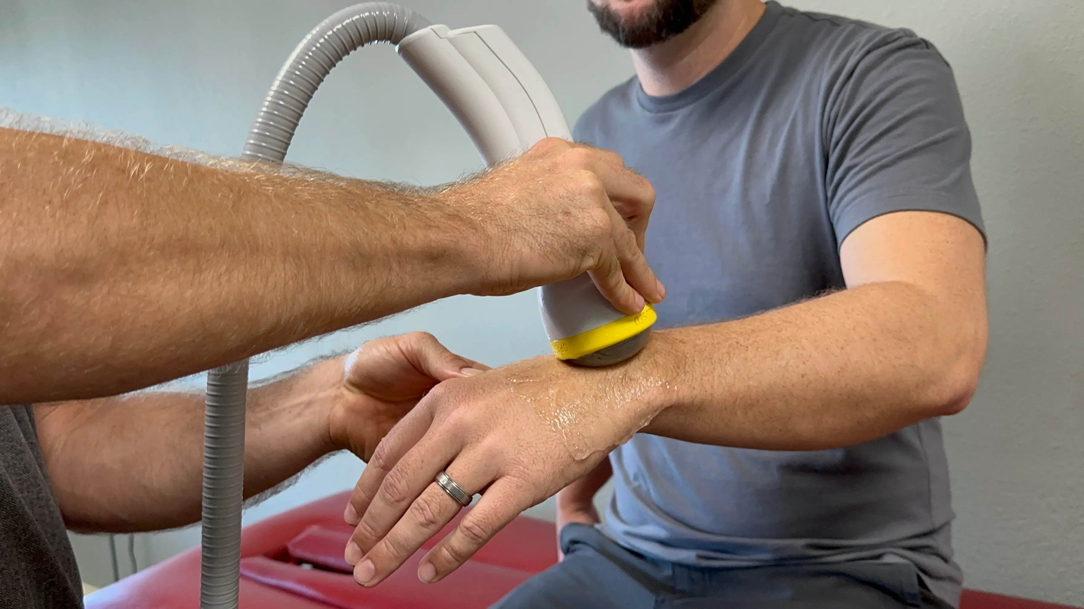A provider applying the SoftWave handheld applicator to a patient's wrist